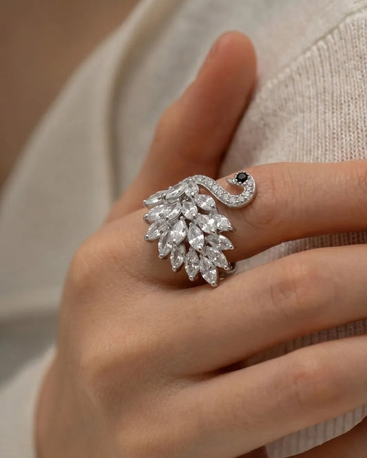 Close-up of a hand wearing a decorative ring with gemstones.