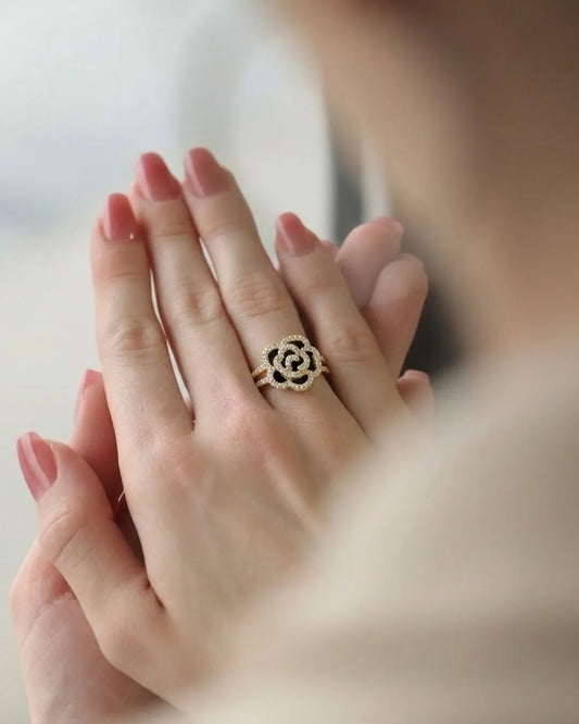 Close-up of a hand wearing a decorative ring with a blurred background