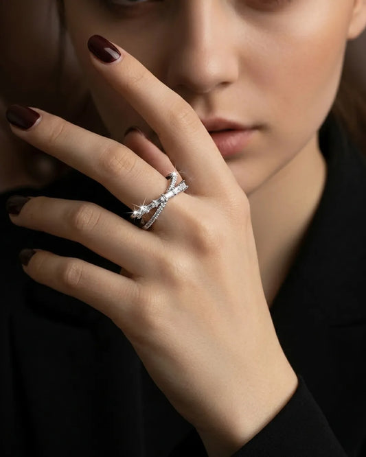 Close-up of a hand wearing a diamond ring with a blurred background