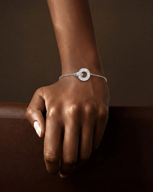 Silver bracelet on a wrist against a dark brown background