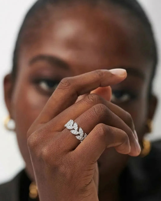 Close-up of a woman's hand wearing a diamond ring with a blurred background