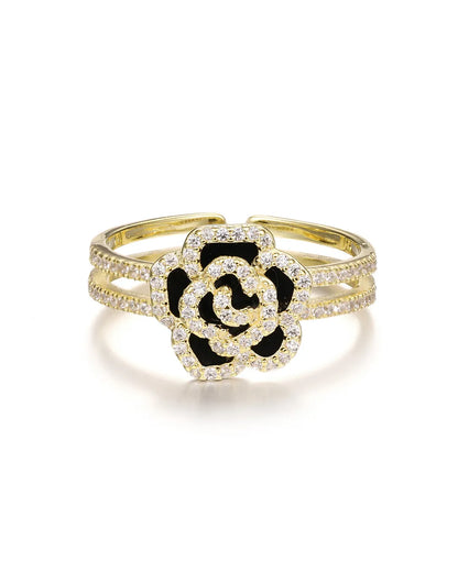 Gold bracelet with a black and white flower design on a white background