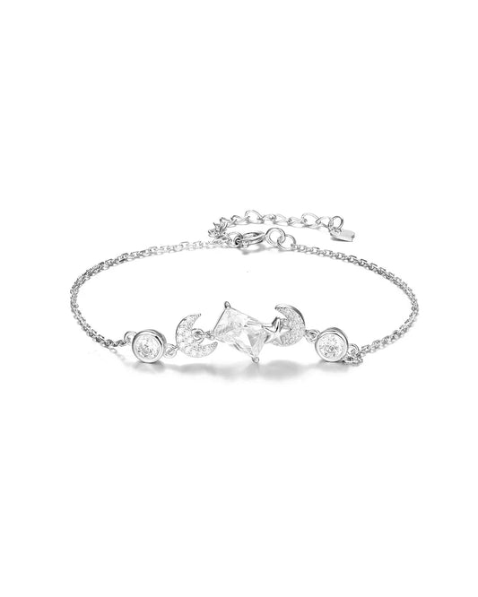 Silver bracelet with star and moon charms on a white background