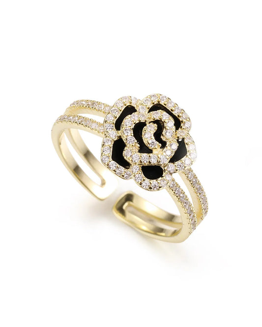 Gold ring with black and white design on a white background