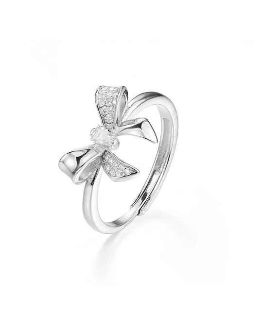 Silver bow-shaped ring with small diamonds on a white background