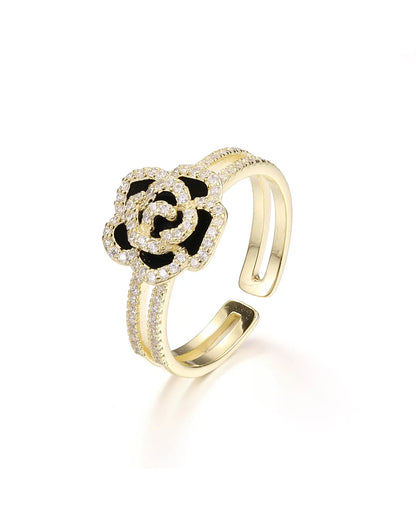 Gold ring with a black flower design on a white background