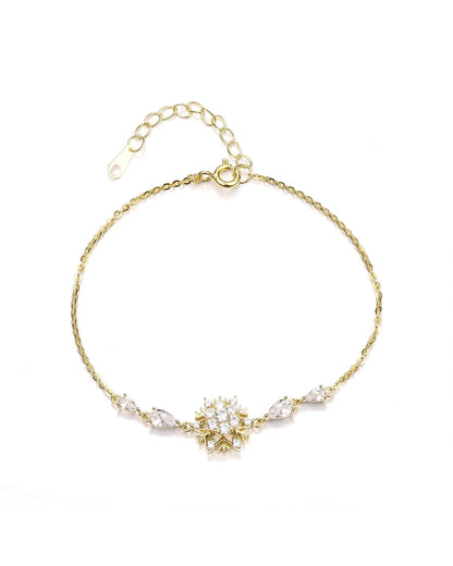 Gold bracelet with floral design and pearls on a white background