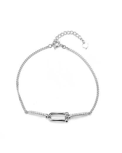Silver bracelet with a rectangular clasp on a white background