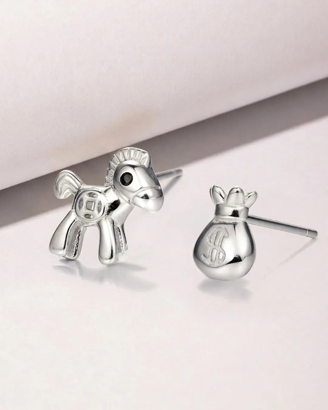 Silver horse-shaped earrings on a light background