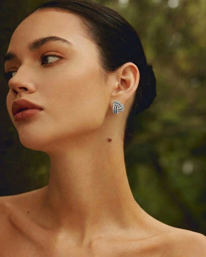 Close-up of a woman wearing earrings with a blurred natural background