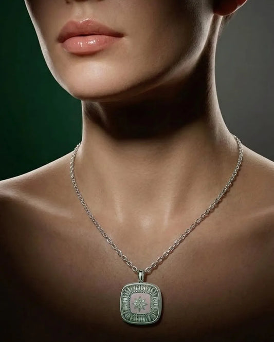 Close-up of a person wearing a silver necklace with a green pendant against a dark background