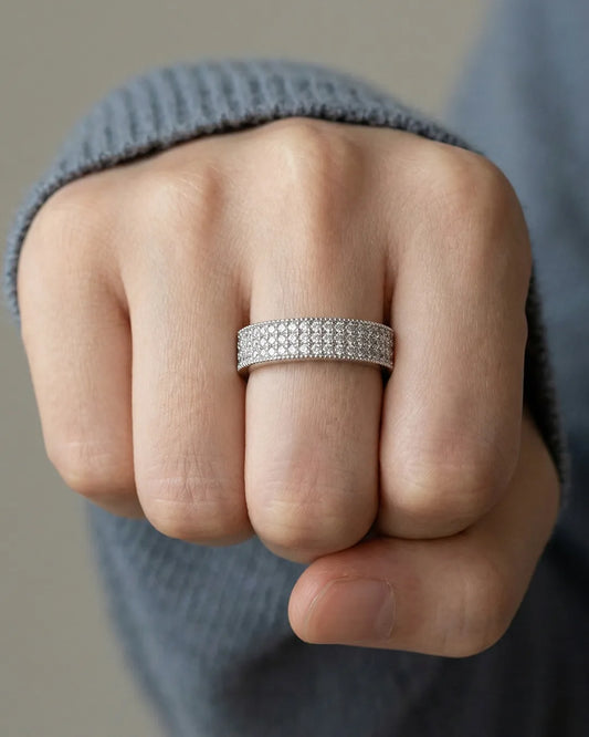 Close-up of a hand wearing a silver ring with a textured band.
