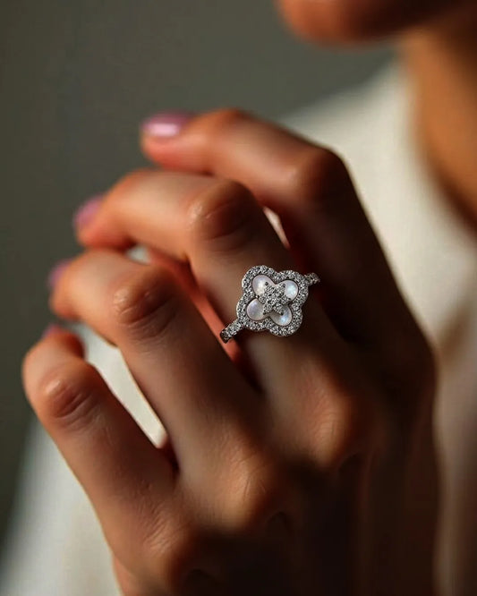 Close-up of a hand wearing a decorative ring with a blurred background