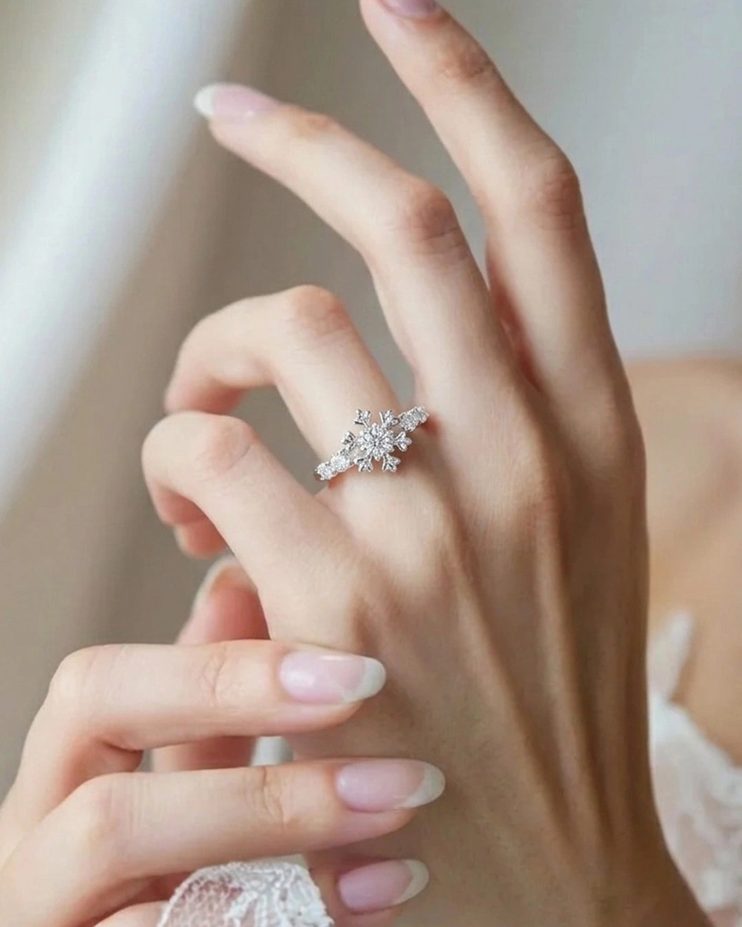 Close-up of a hand wearing a diamond ring with a blurred background