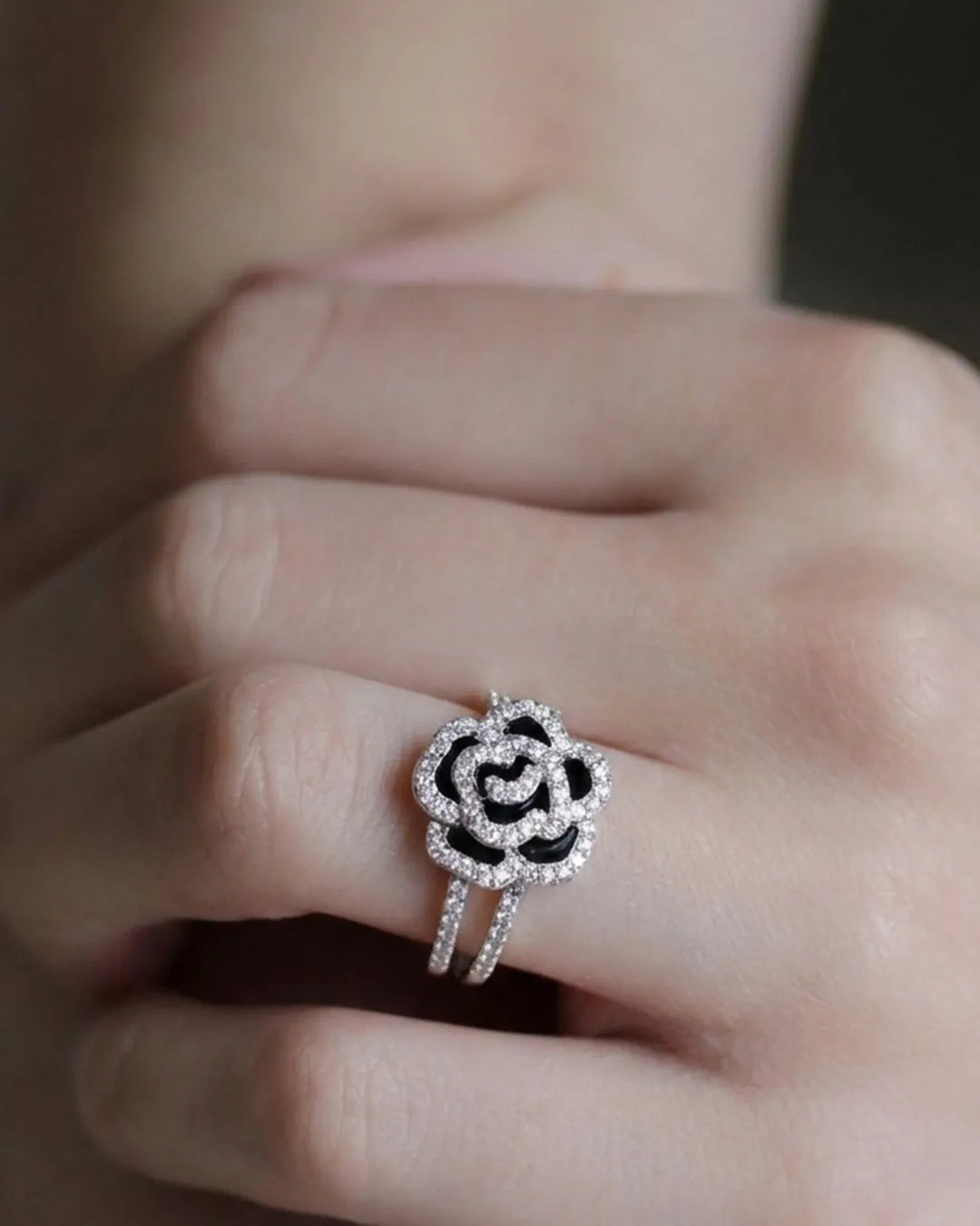 Silver ring with black center on a finger
