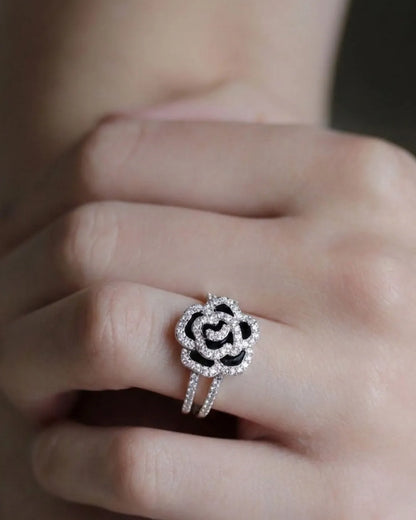 Silver ring with black center on a finger