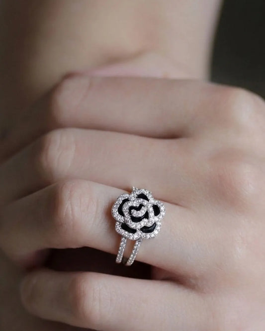 Silver ring with black center on a finger