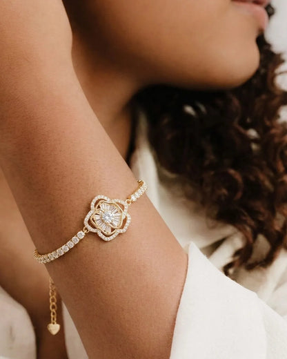 Close-up of a person's wrist wearing a gold bracelet with a diamond-like stone.