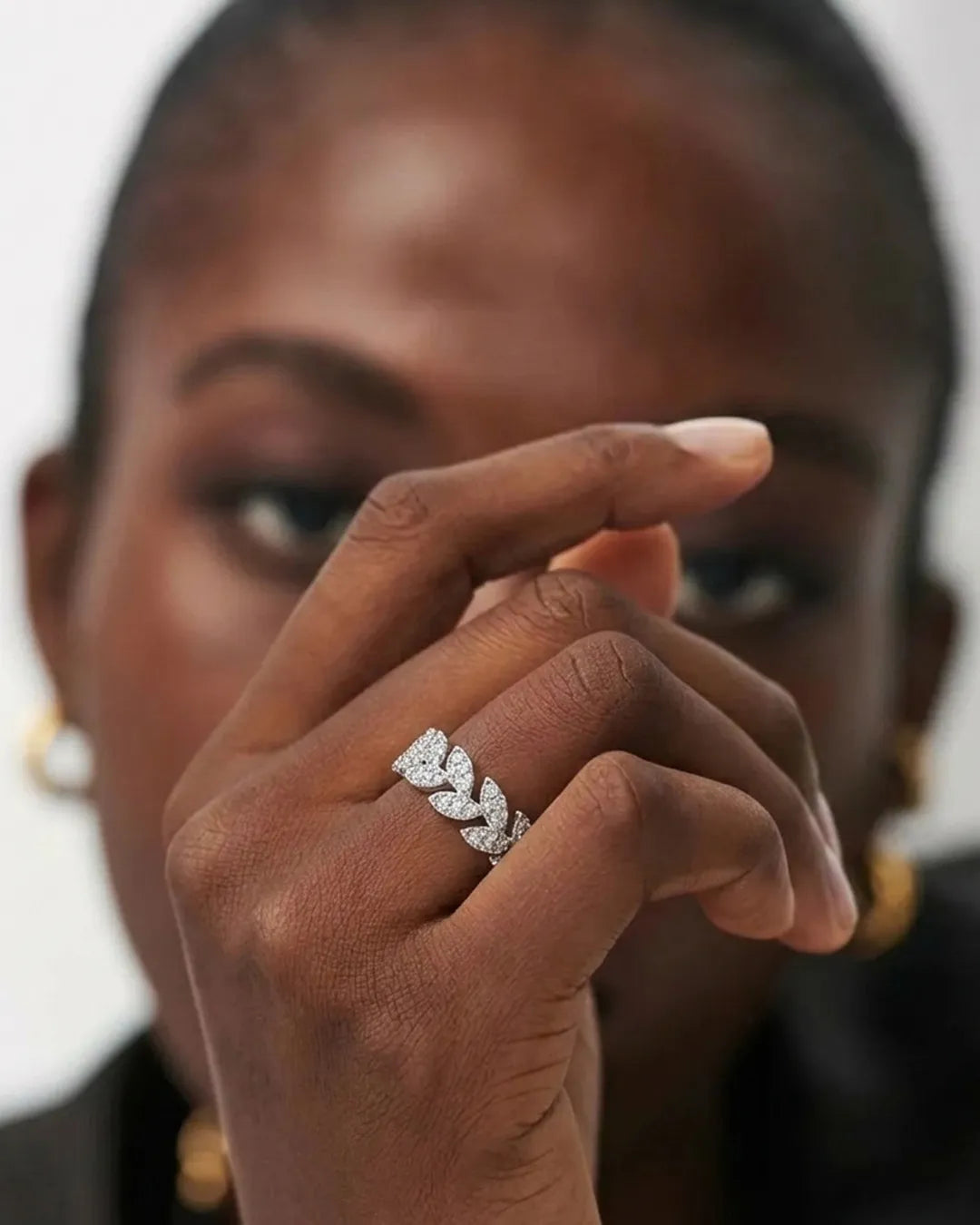 Close-up of a woman's hand wearing a diamond ring with a blurred background