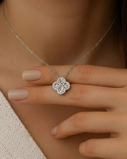 Silver necklace with a floral pendant worn by a person