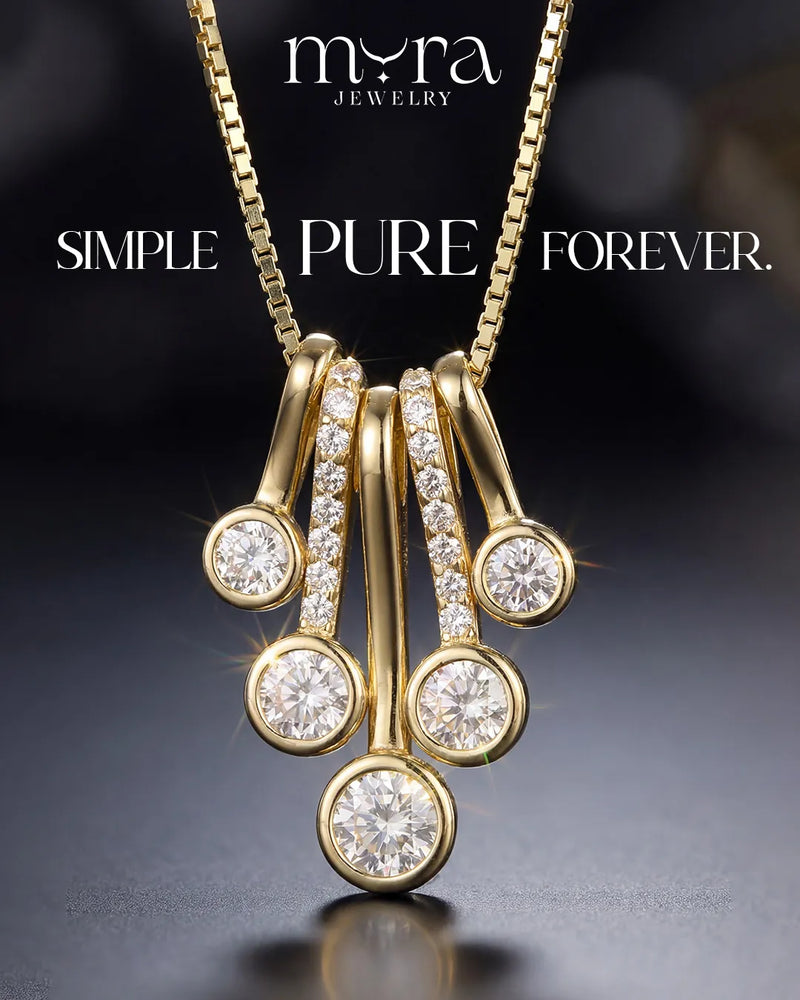 Gold necklace with diamond pendants on a dark background, featuring 'myra jewelry' branding.